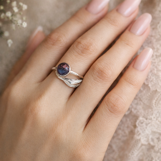 Hand wearing a silver ring with wedding flowers preserved within it