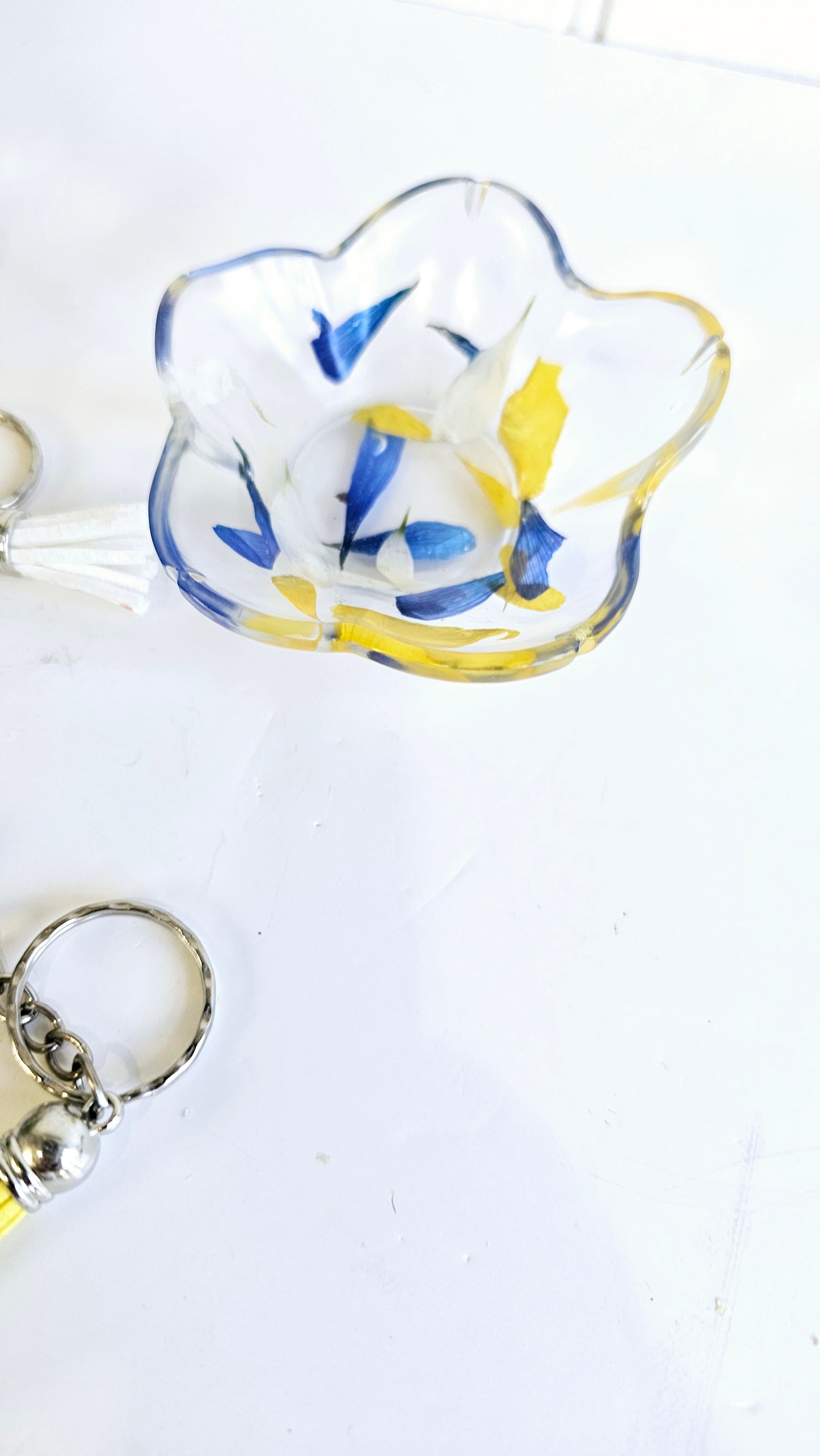 resin trinket dish with blue and yellow design on a white background