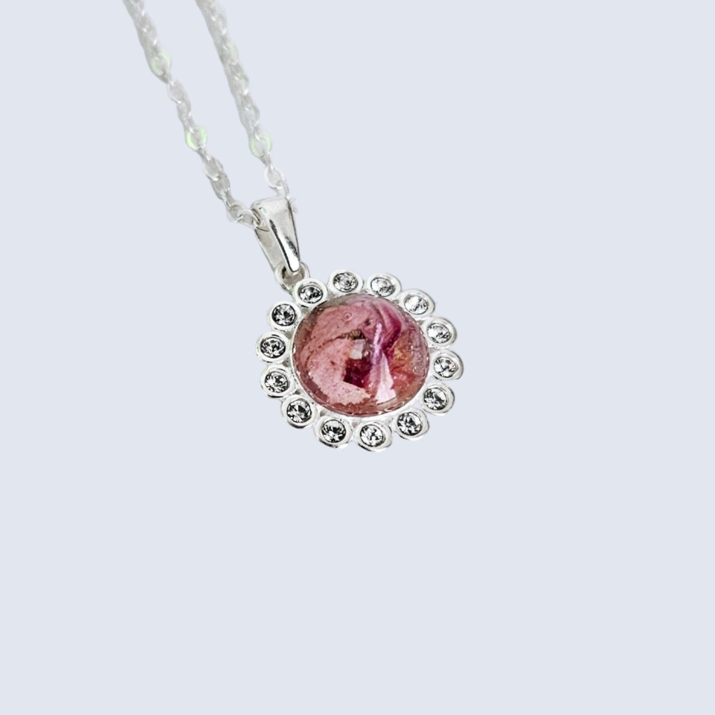 flower preservation Necklace with a pink pendant on a light gray background