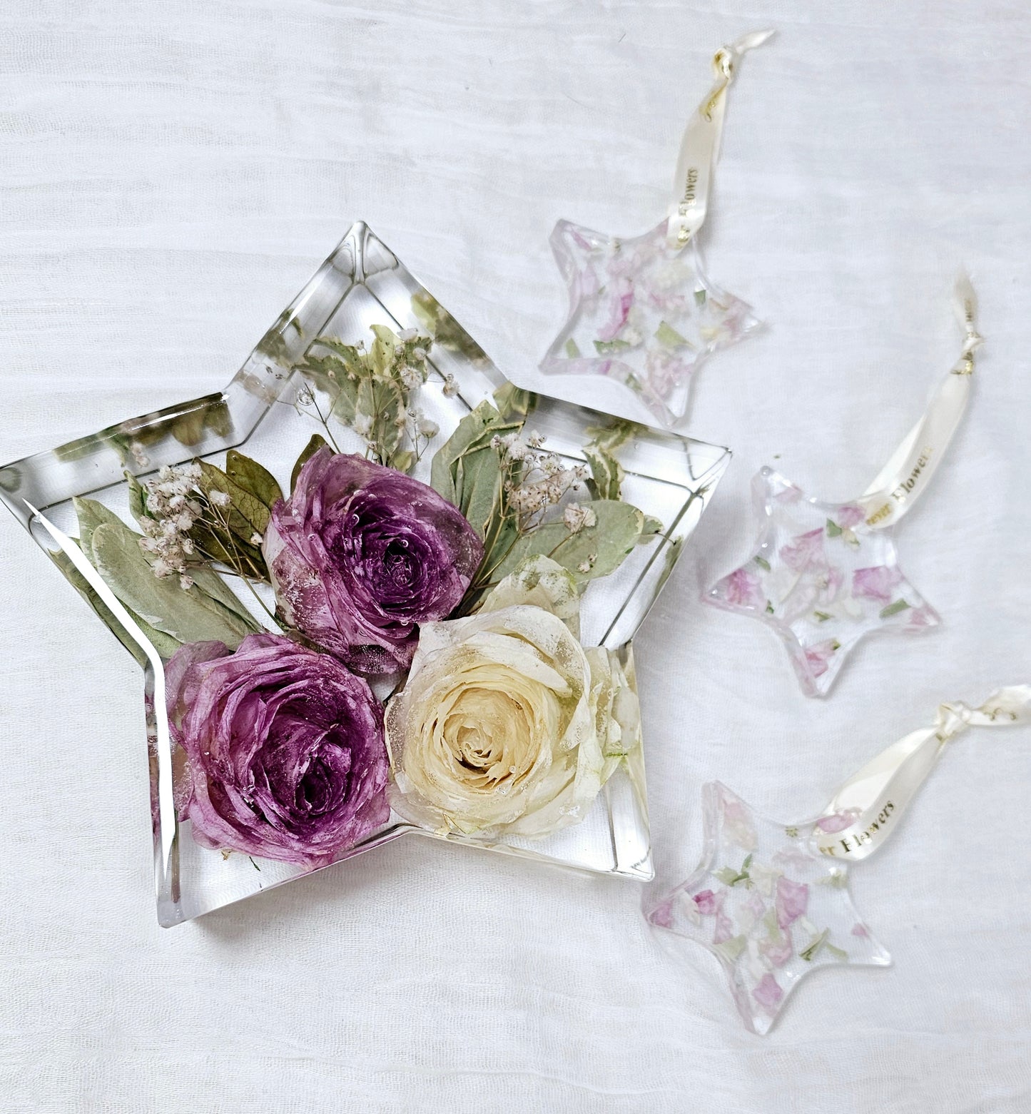 crystal clear resin in the shape of star with pink and white roses preserved within it