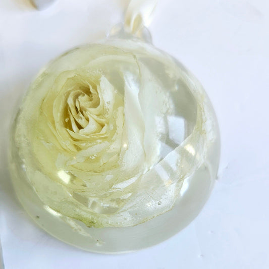 Clear resin bauble with a rose design on a white background