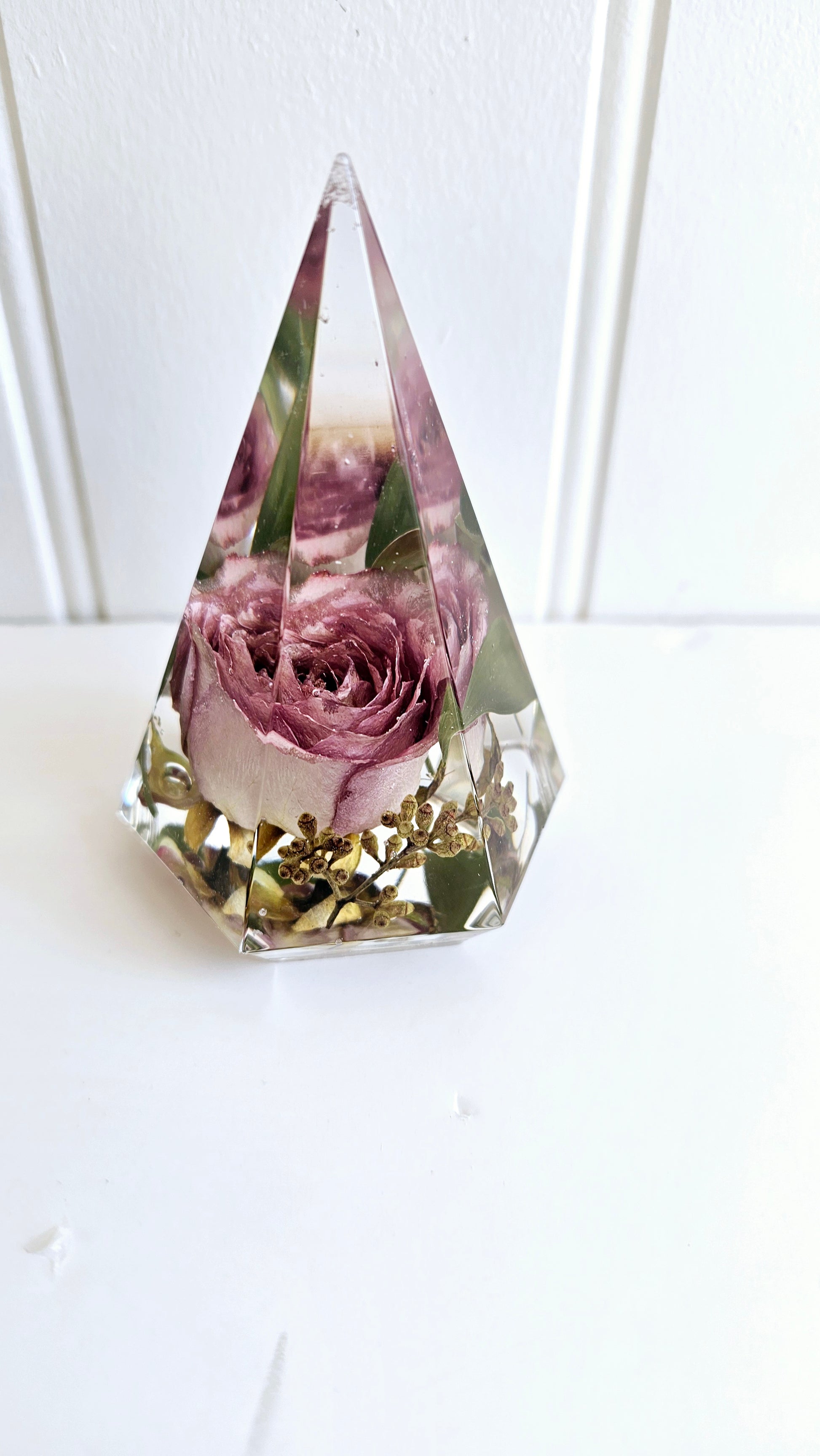 pyramid crystal shaped resin ring holder with preserved flowers on a white background