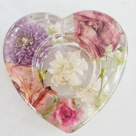 Heart-shaped resin tealight holder with preserved flowers on a white background