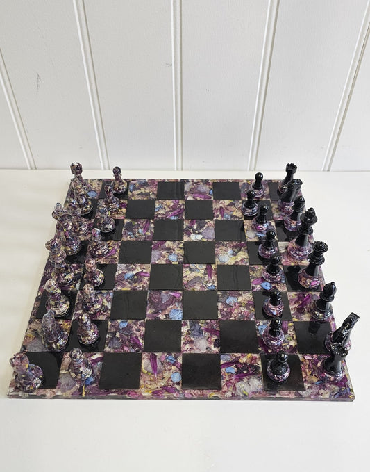 Resin flower preservation chessboard with black and floral pieces on a white background