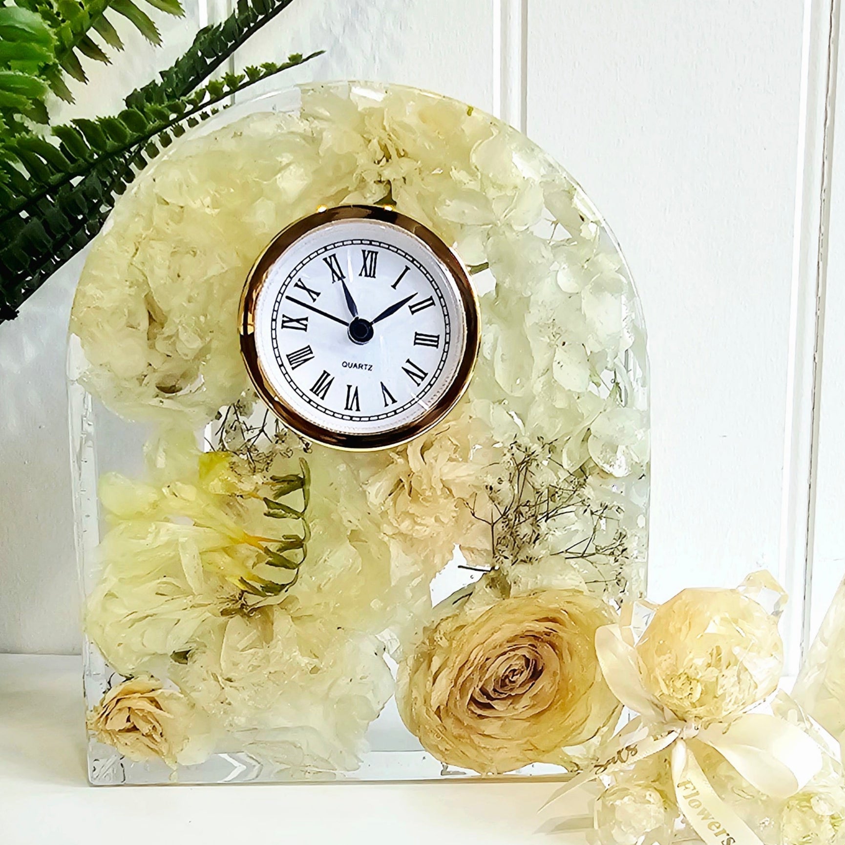 Decorative resin clock with flowers in  on a white background