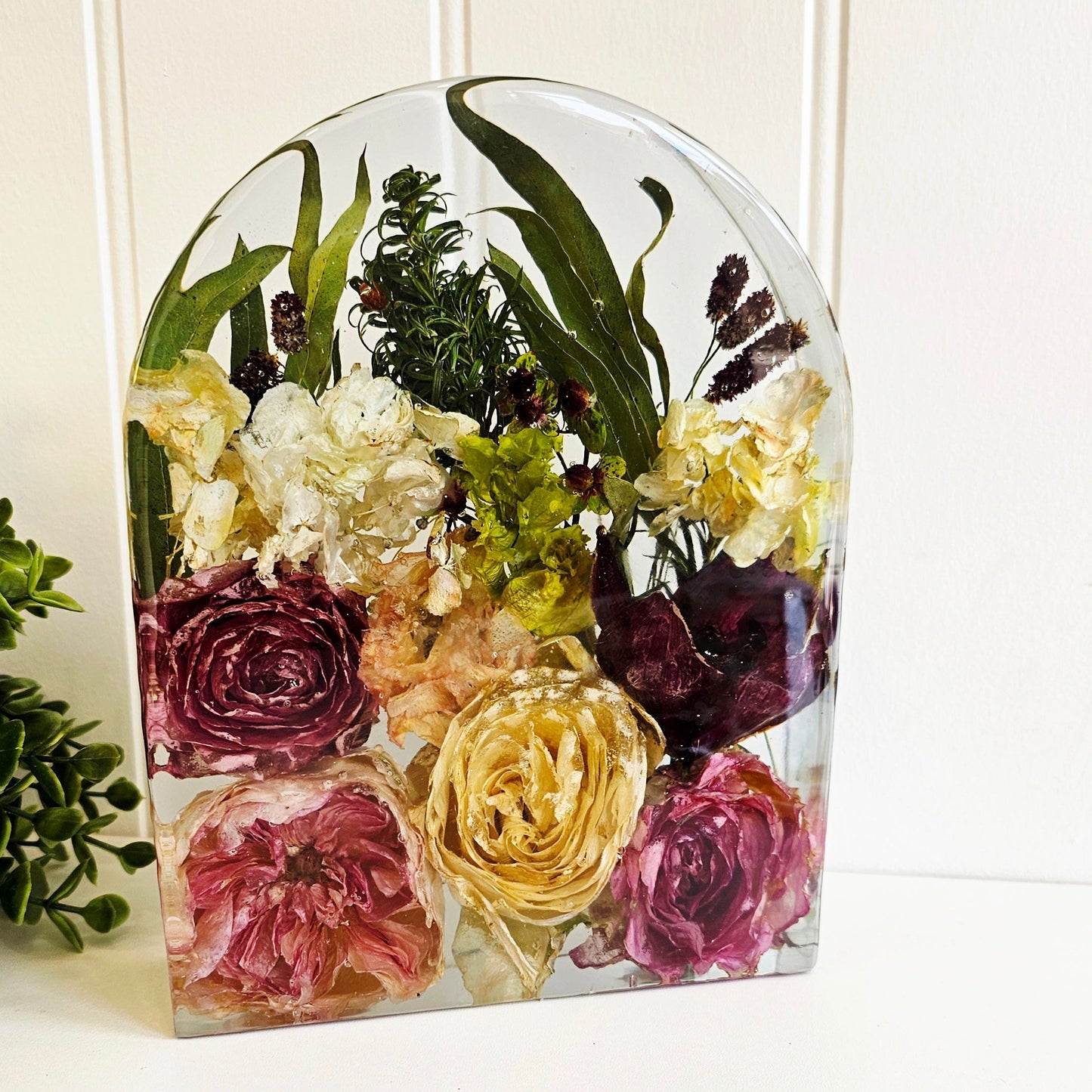 Clear resin arch with preserved flowers on a white background
