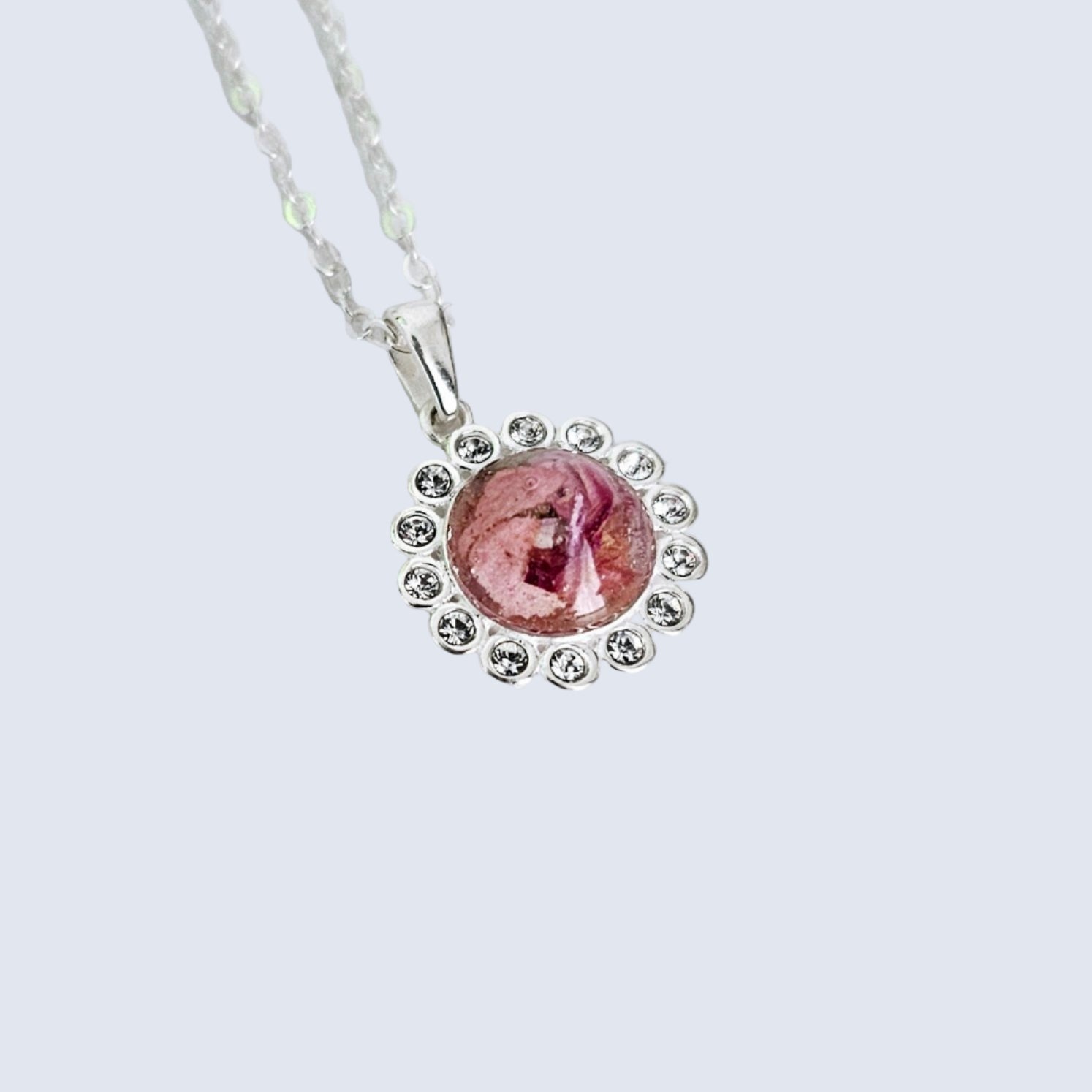 flower preservation Necklace with a pink pendant on a light gray background