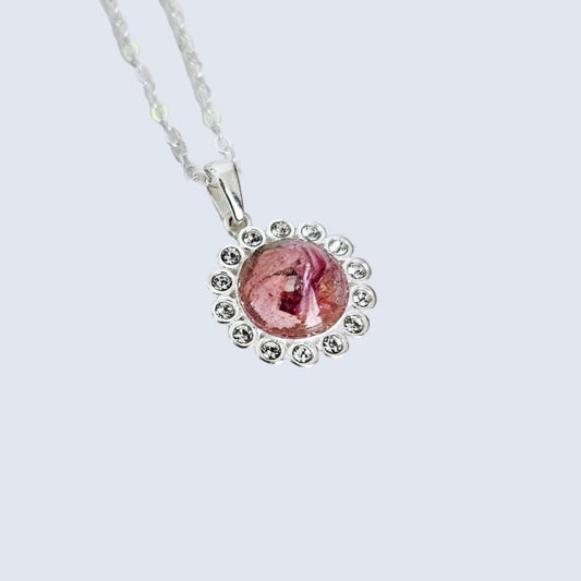 flower preservation Necklace with a pink pendant on a light gray background