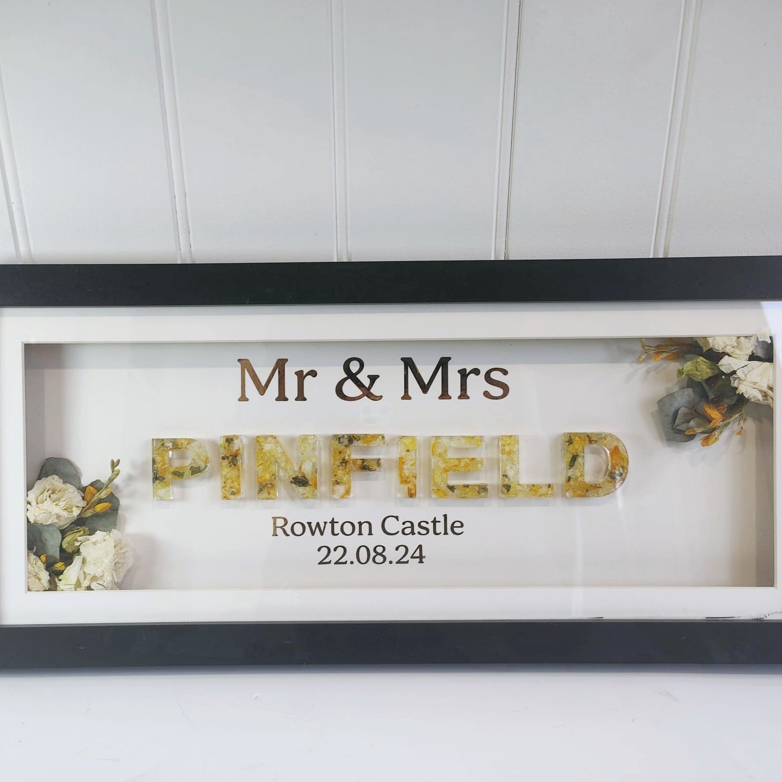 flower preservation name name made from resin letters framed in a black frame with flowers 