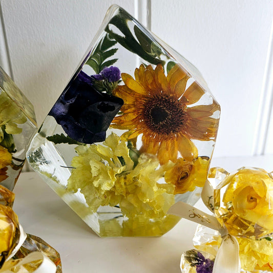 Clear resin gem with pressed flowers on a white surface
