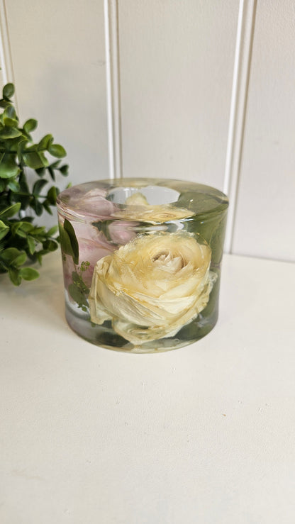 Clear cylindrical vase with preserved flowers against a white background