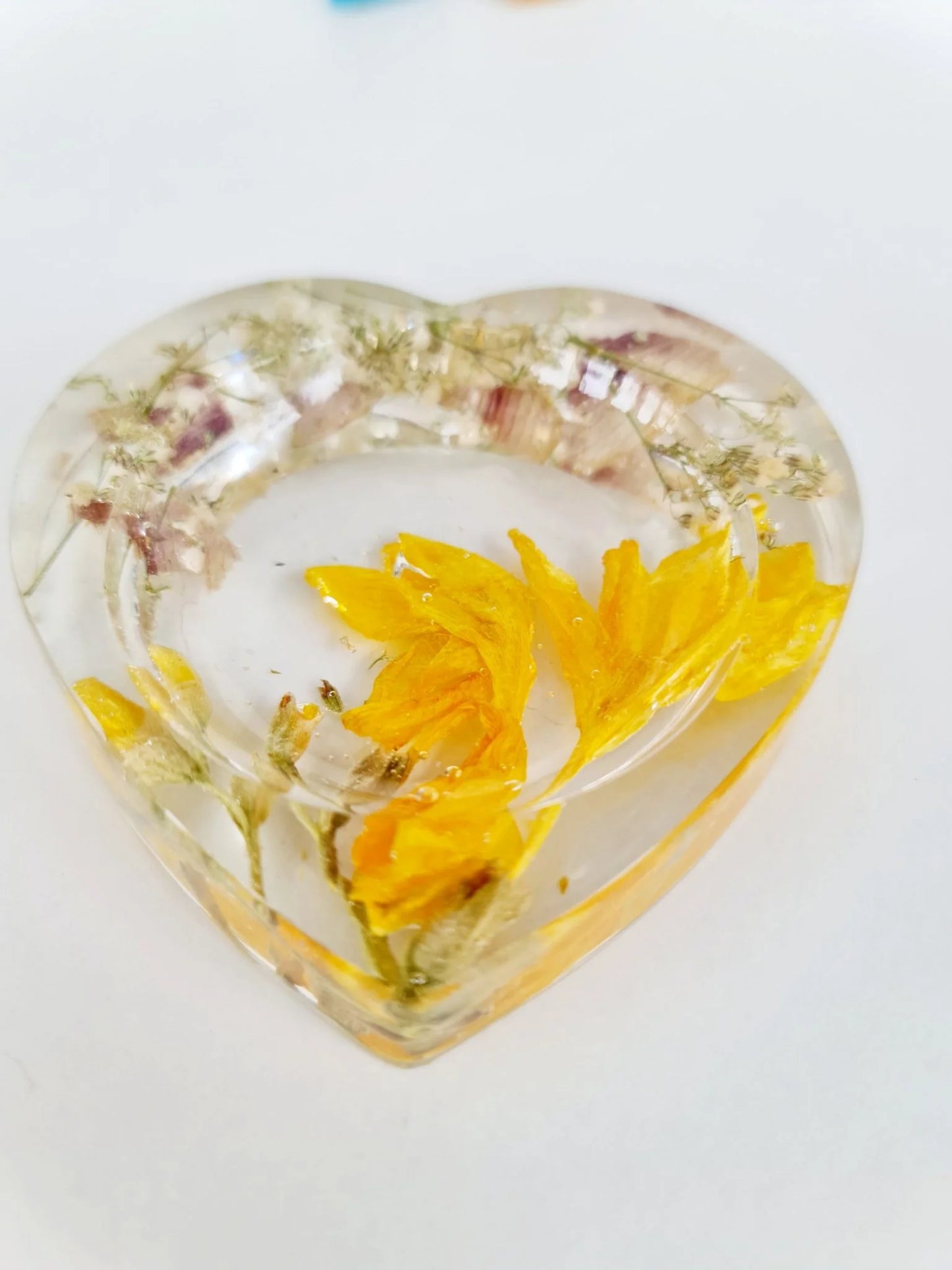 Heart-shaped resin trinket dish with a yellow flower and transparent resin