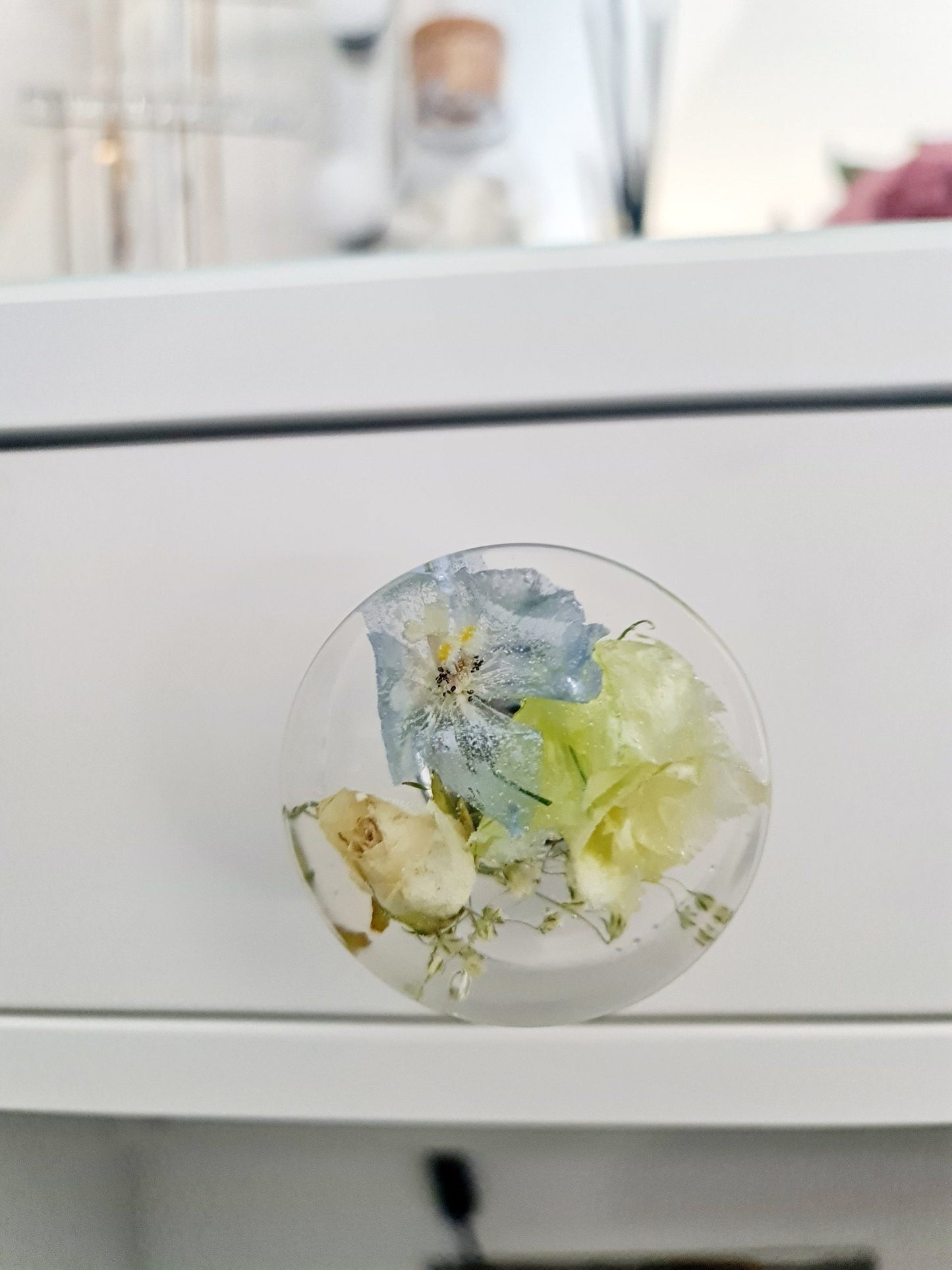 Resin Decorative knob with floral design on a white cabinet