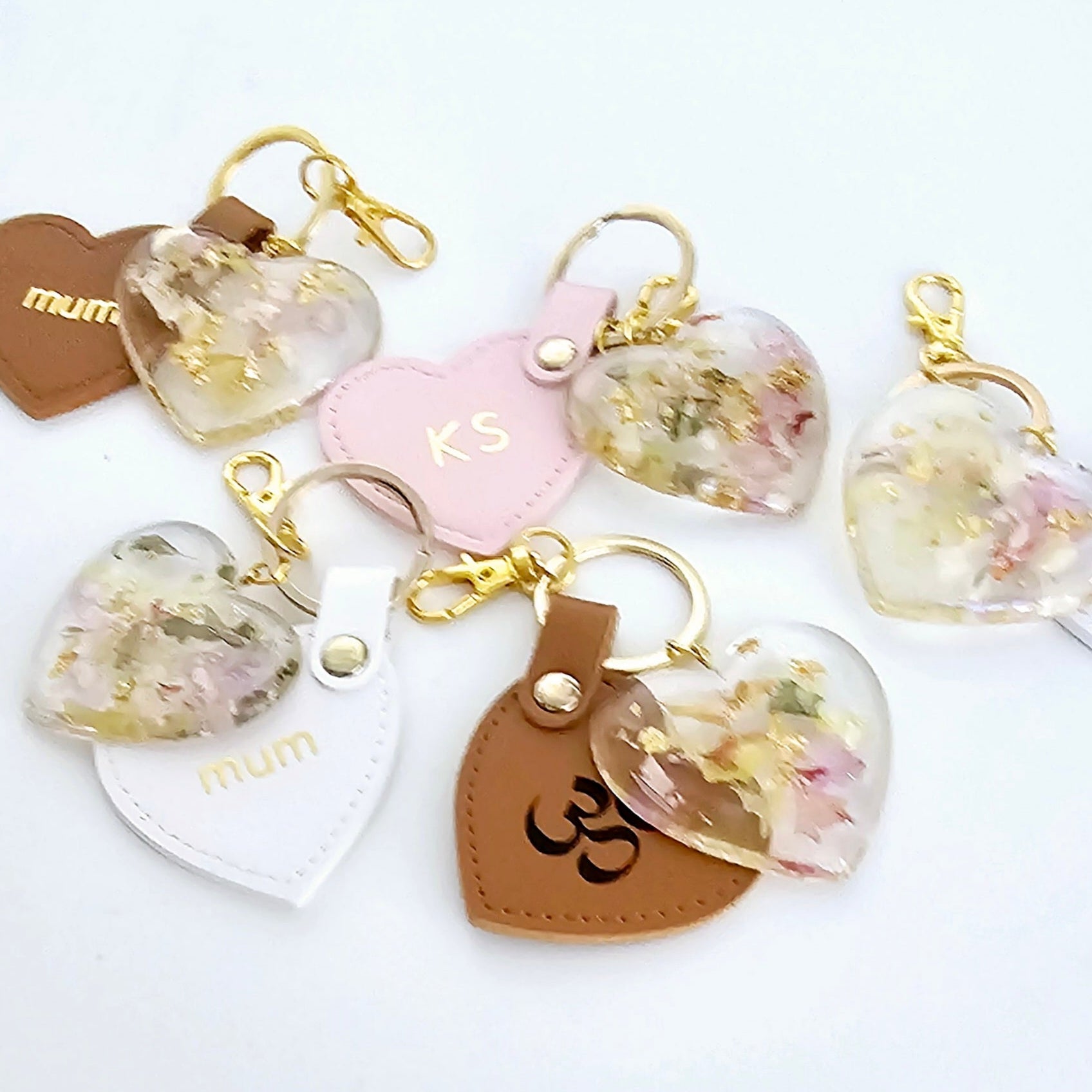 Heart-shaped keychains with floral designs on a white background