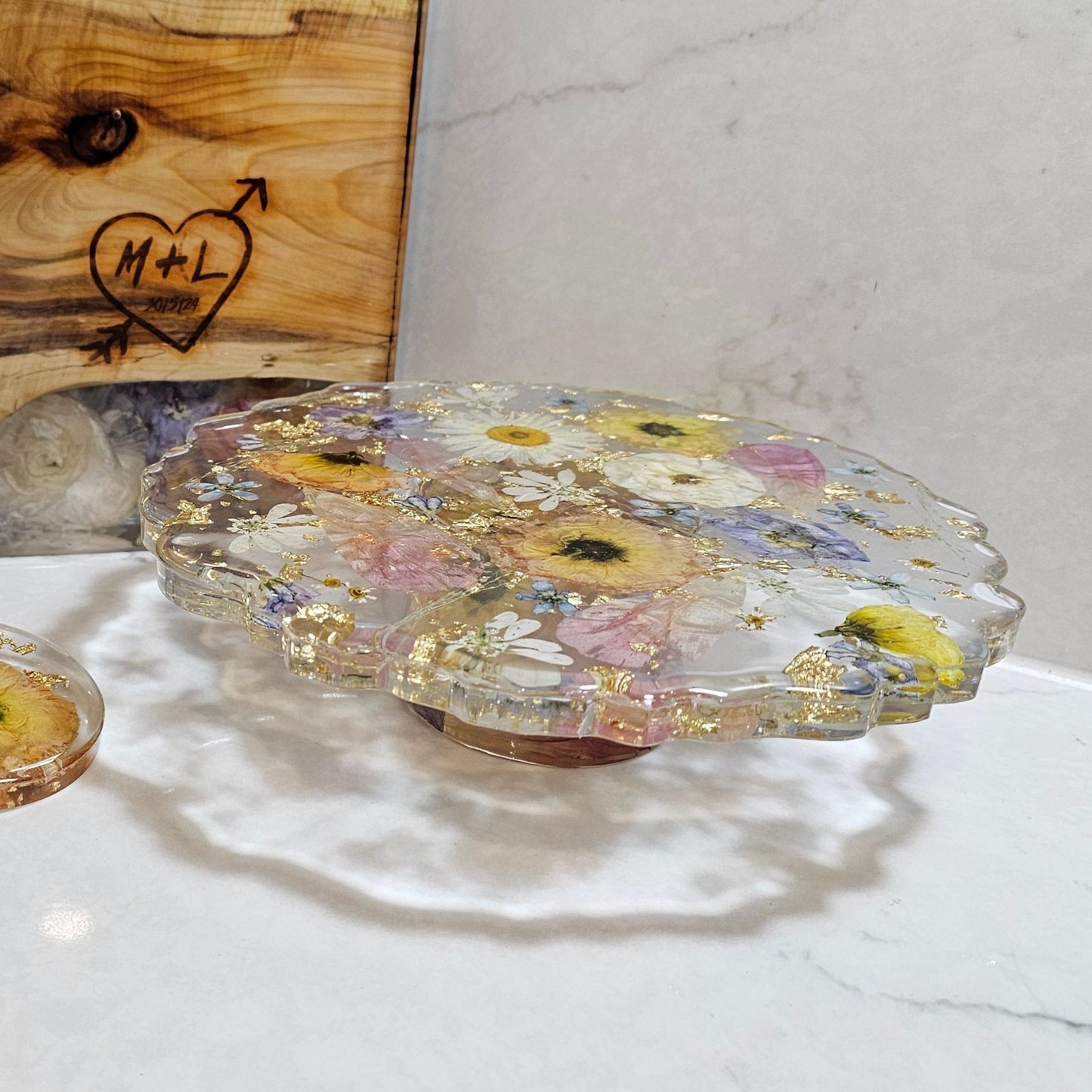 Decorative glass plates with floral designs on a white surface, with a wooden box in the background.