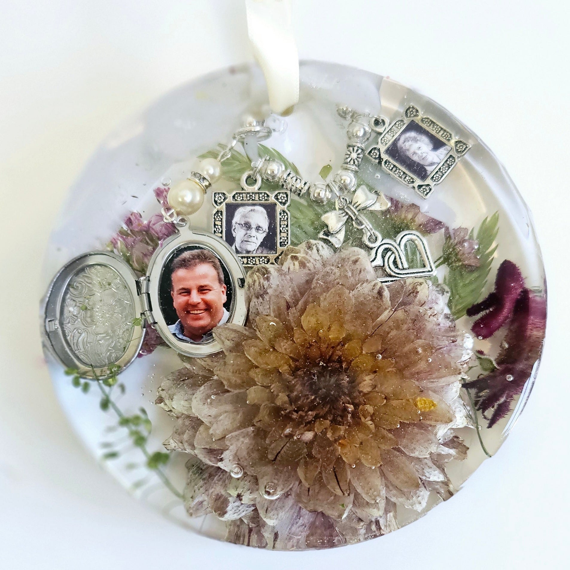 round hanging disk ornament made from resin with flowers preserved within 