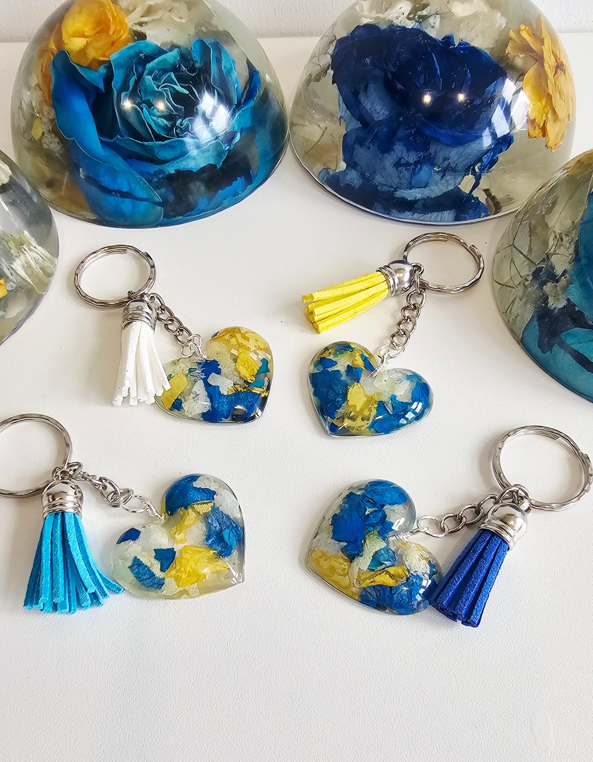 resin keychains with blue and yellow floral designs on a white background