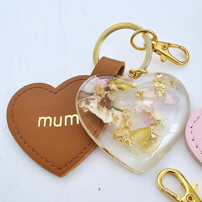 Heart-shaped keychain with floral design and 'mum' tag on a white background