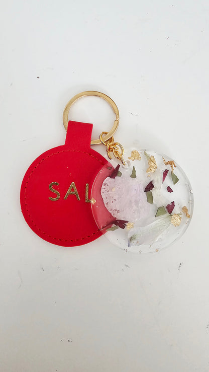 Red keychain with 'SAL' and a floral design on a white background