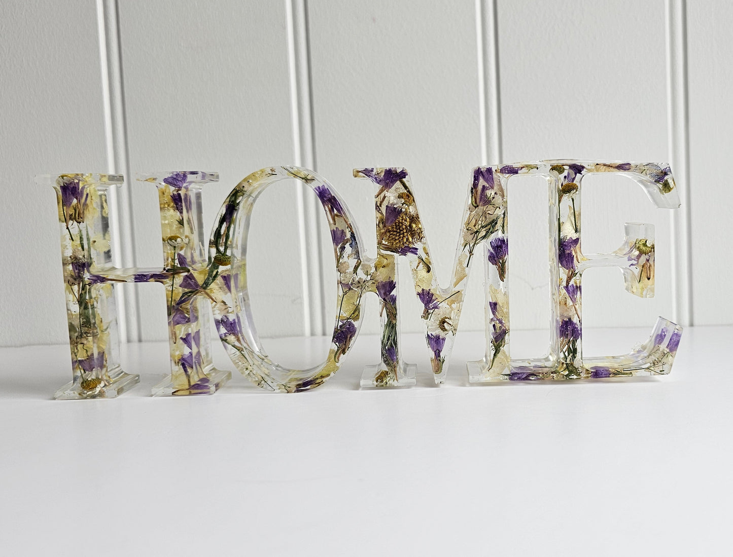 Decorative letters spelling 'HOME' with floral patterns on a white background