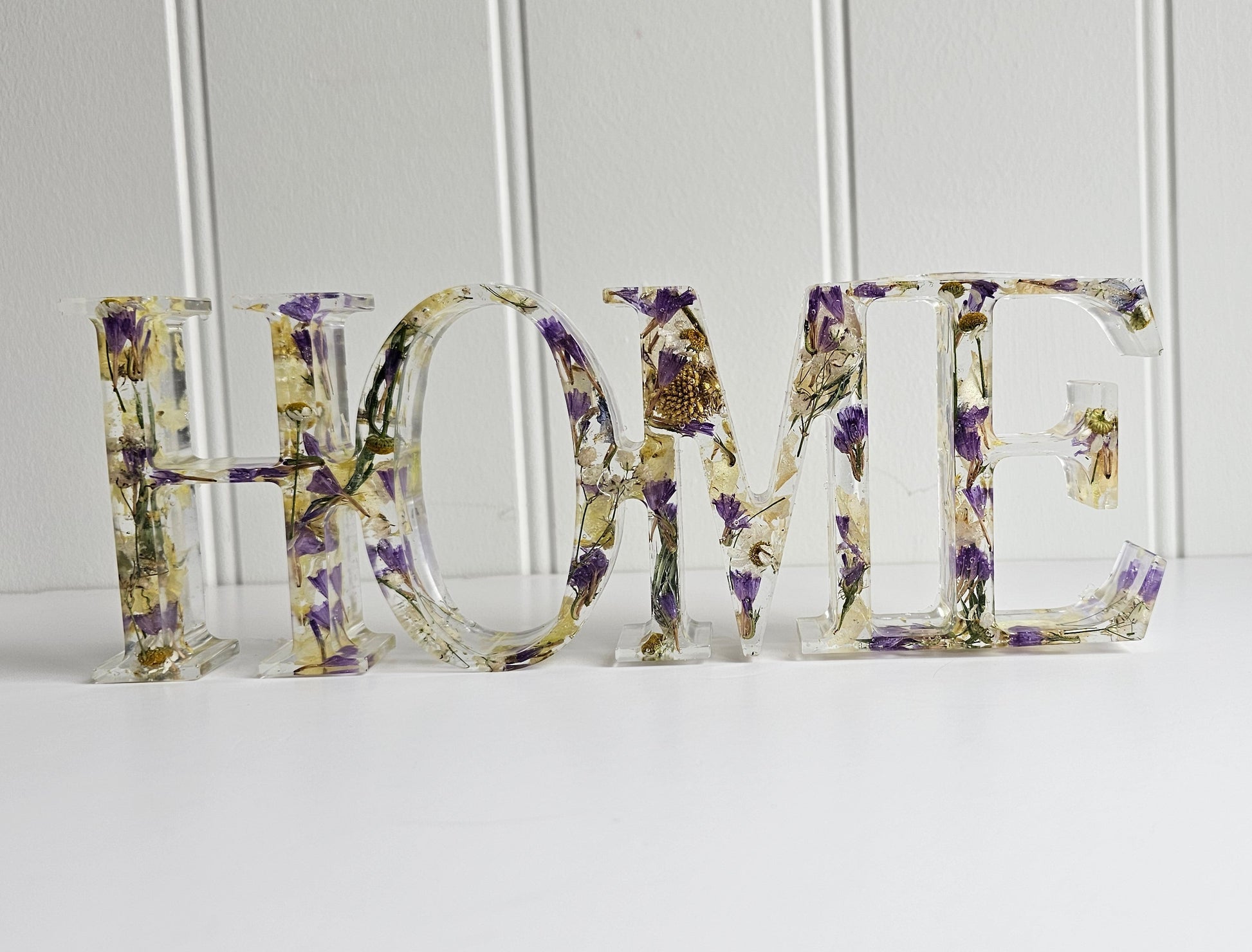 Decorative letters spelling 'HOME' with floral patterns on a white background