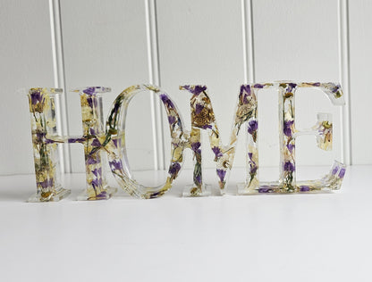Decorative letters spelling 'HOME' with floral patterns on a white background