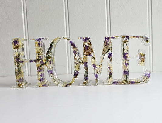Decorative letters spelling 'HOME' with floral patterns on a white background