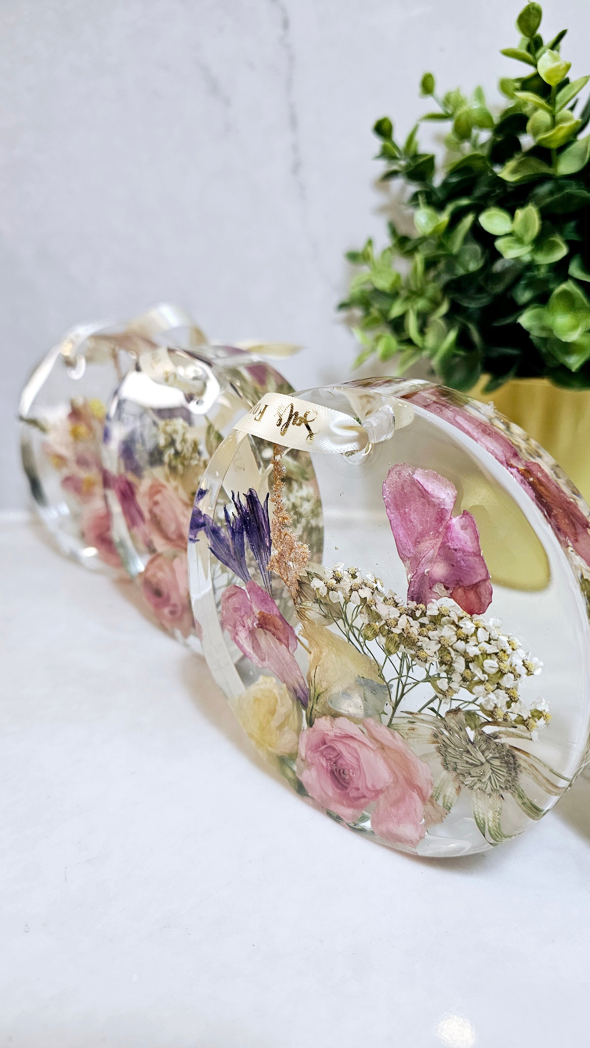 Decorative resin hanging disks with floral design on a white surface