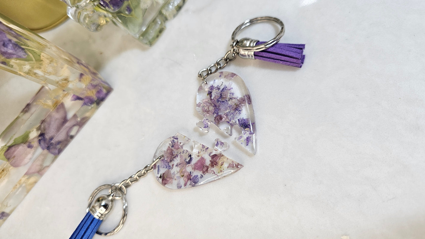 Keychain with heart-shaped purple and white resin charms on a white surface
