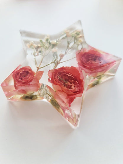 Star-shaped resin coaster with red roses and greenery on a white background