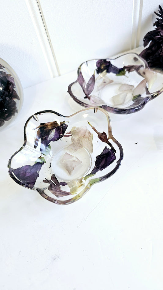 resin flower-shaped containers with dried flowers on a white background