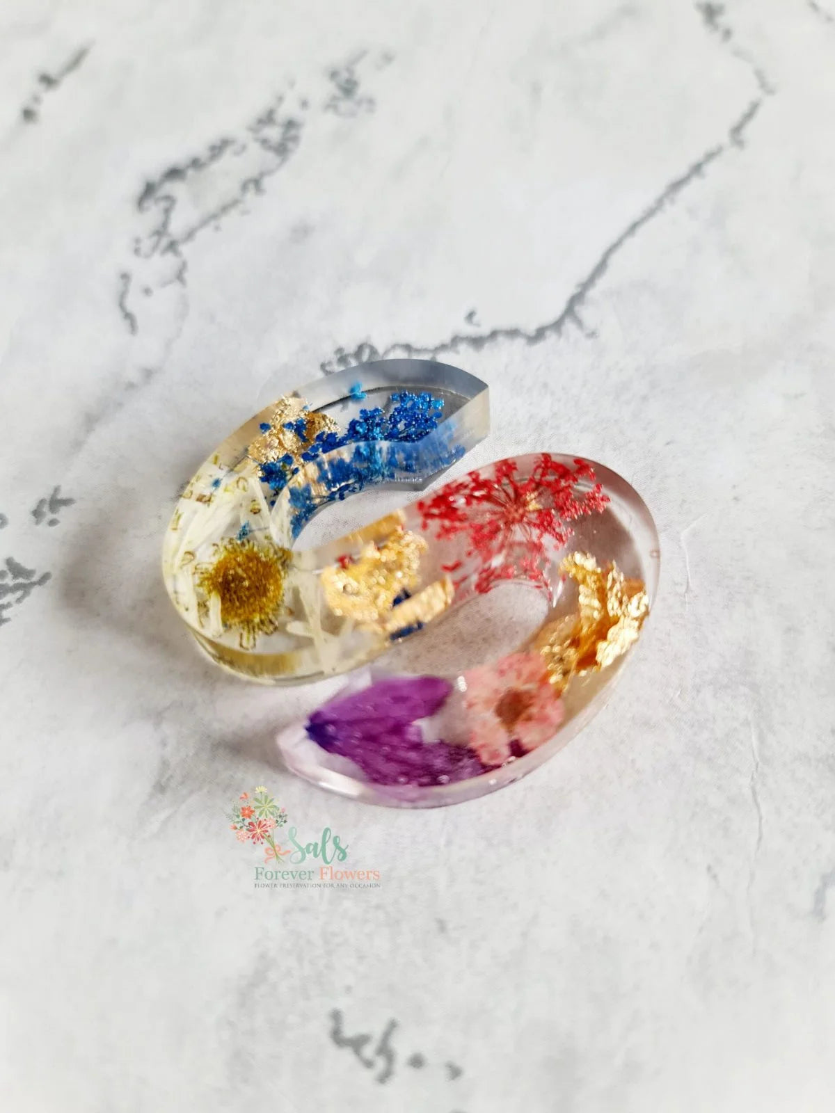small resin letter s full of colourful flowers on a marble background 