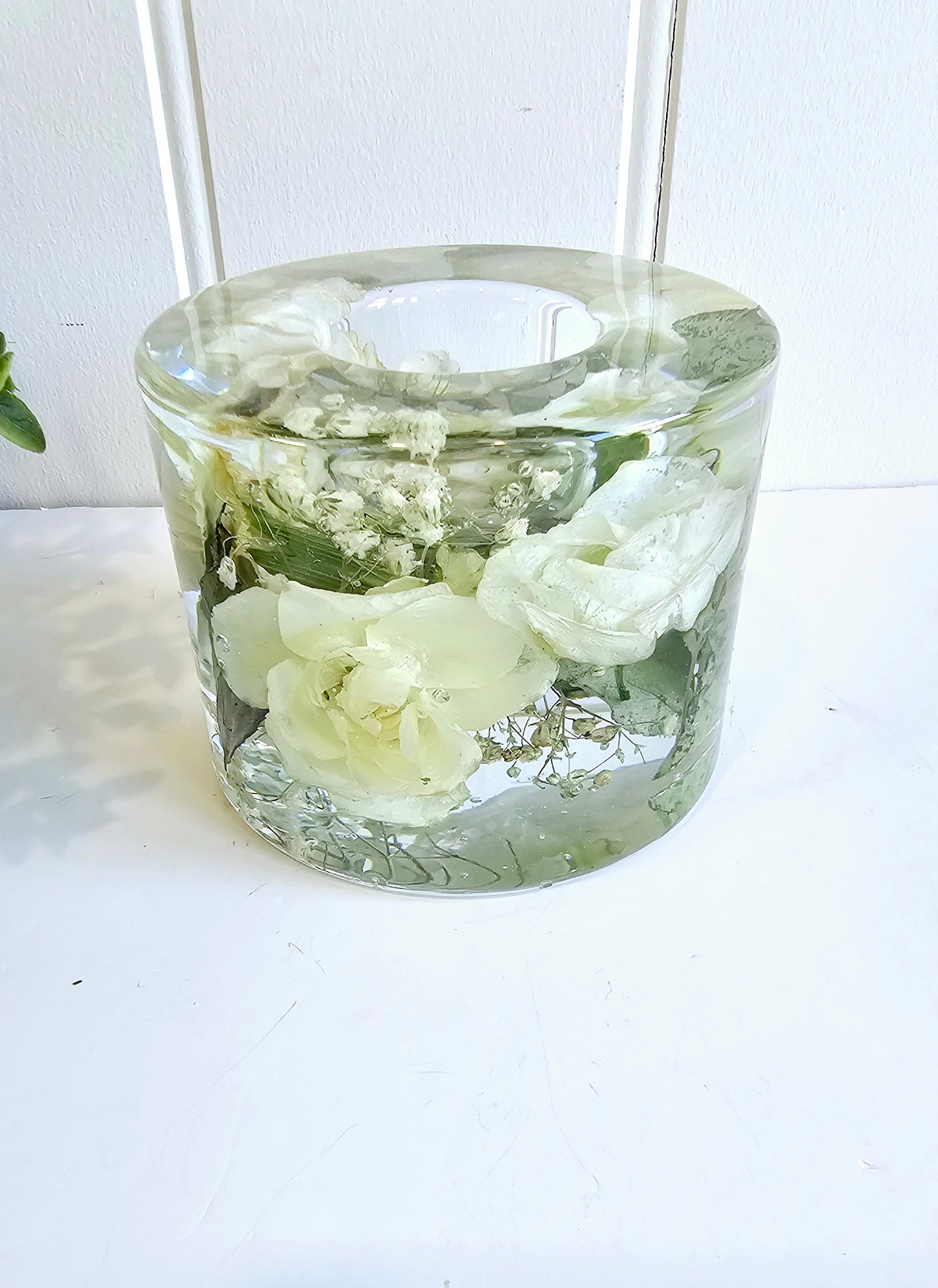 Clear glass vase with white flowers on a white background