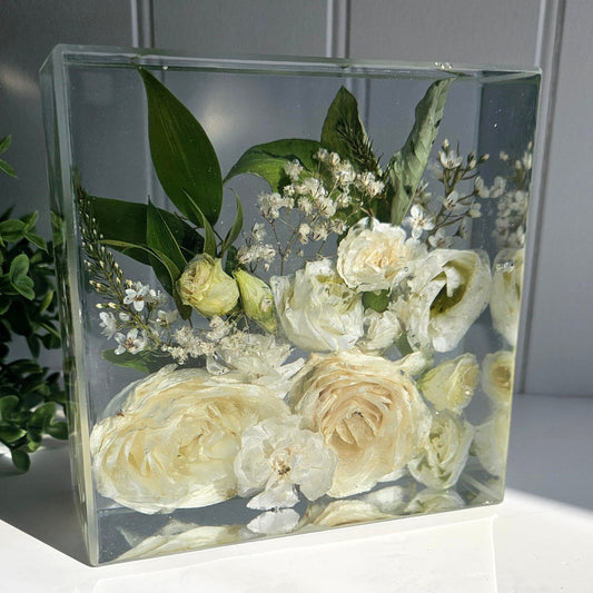 resin block with preserved  wedding flowers on a white surface