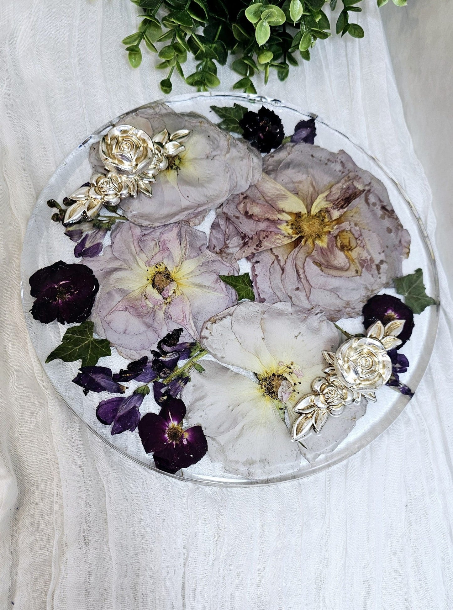 round resin wedding flower preservation tray with fancy handles on a white fabric background 
