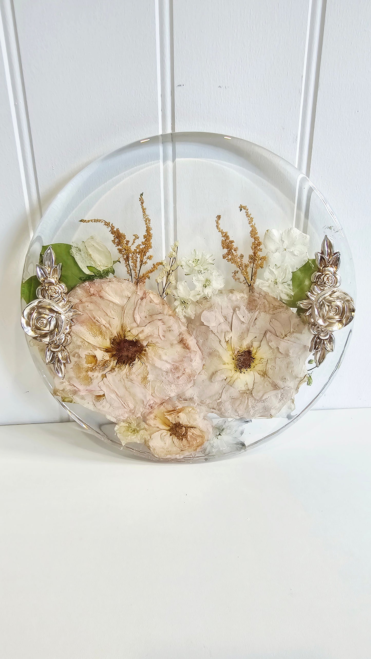 Decorative resin tray with pressed flowers on a white background
