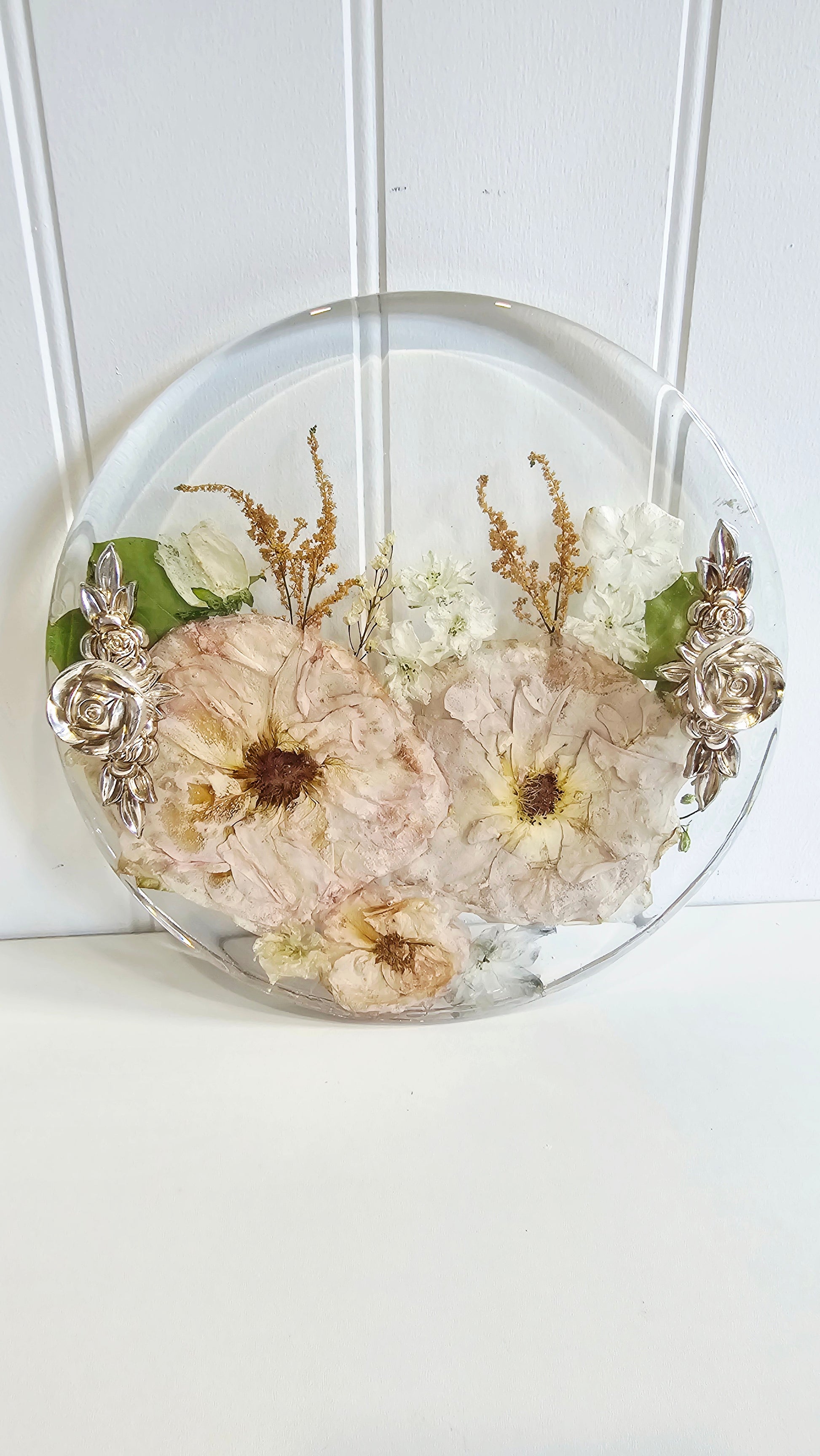 Decorative resin tray with pressed flowers on a white background