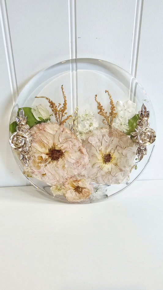 Decorative resin tray with pressed flowers on a white background