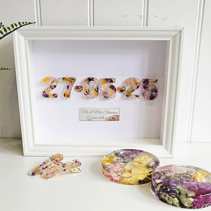 Decorative items including a framed date with floral designs on a white surface.