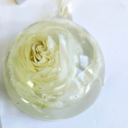 Clear resin bauble with a rose design on a white background