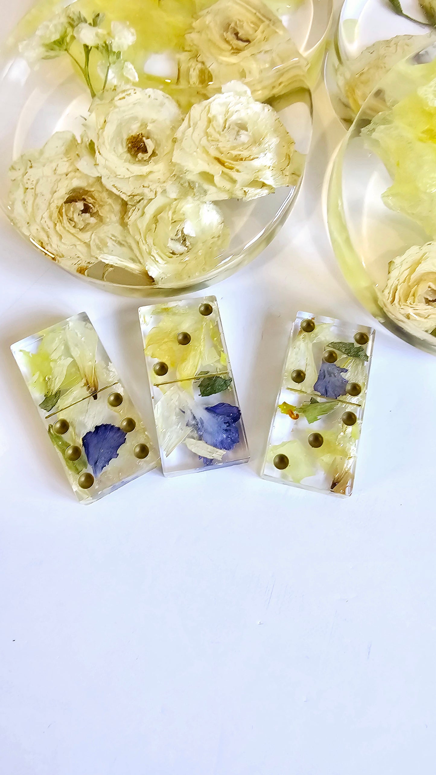 Set of three rectangular resin charms with pressed flowers on a white background