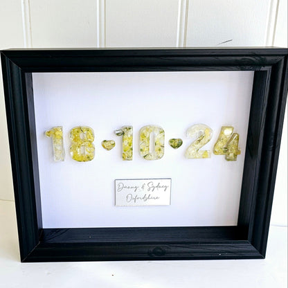 Framed artwork with gold numbers and personalized text on a white background