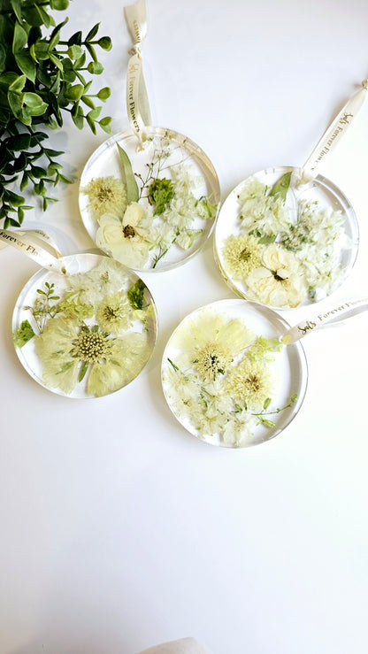 resin decorative hanging disks with pressed flowers on a white surface
