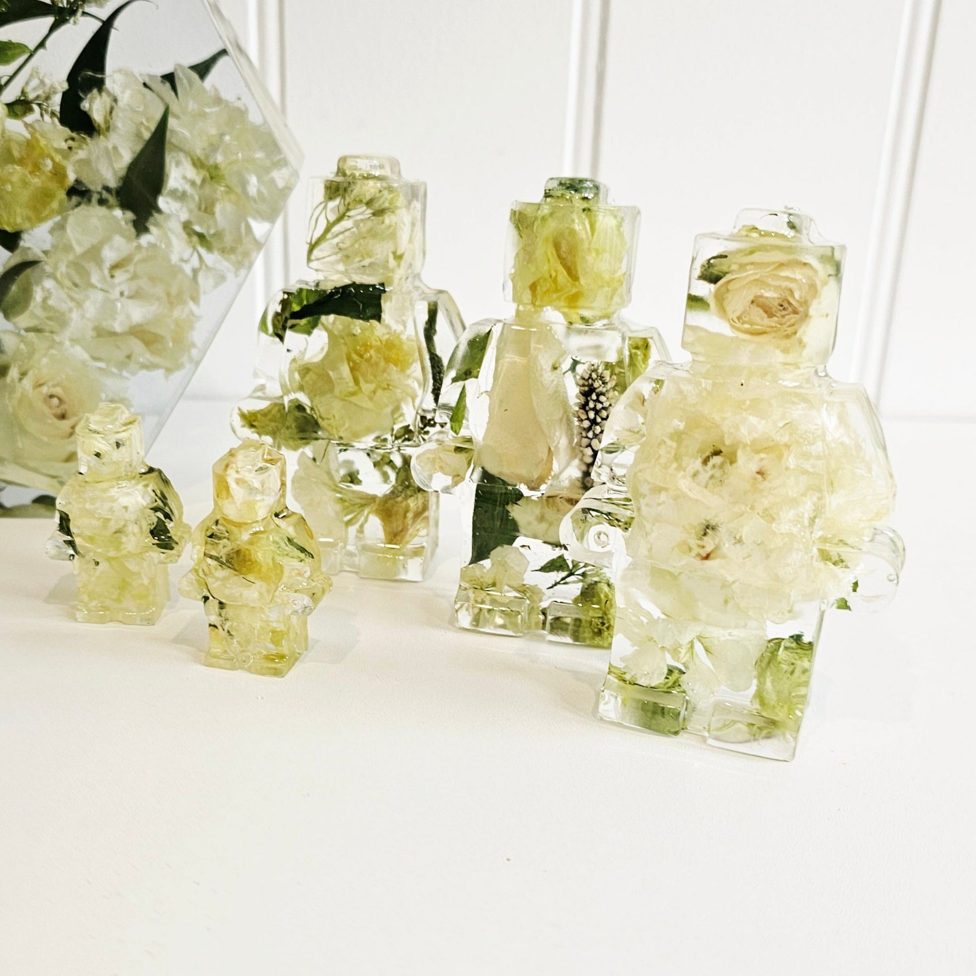 white wedding flowers preserved in clear resin in the shape of lego men